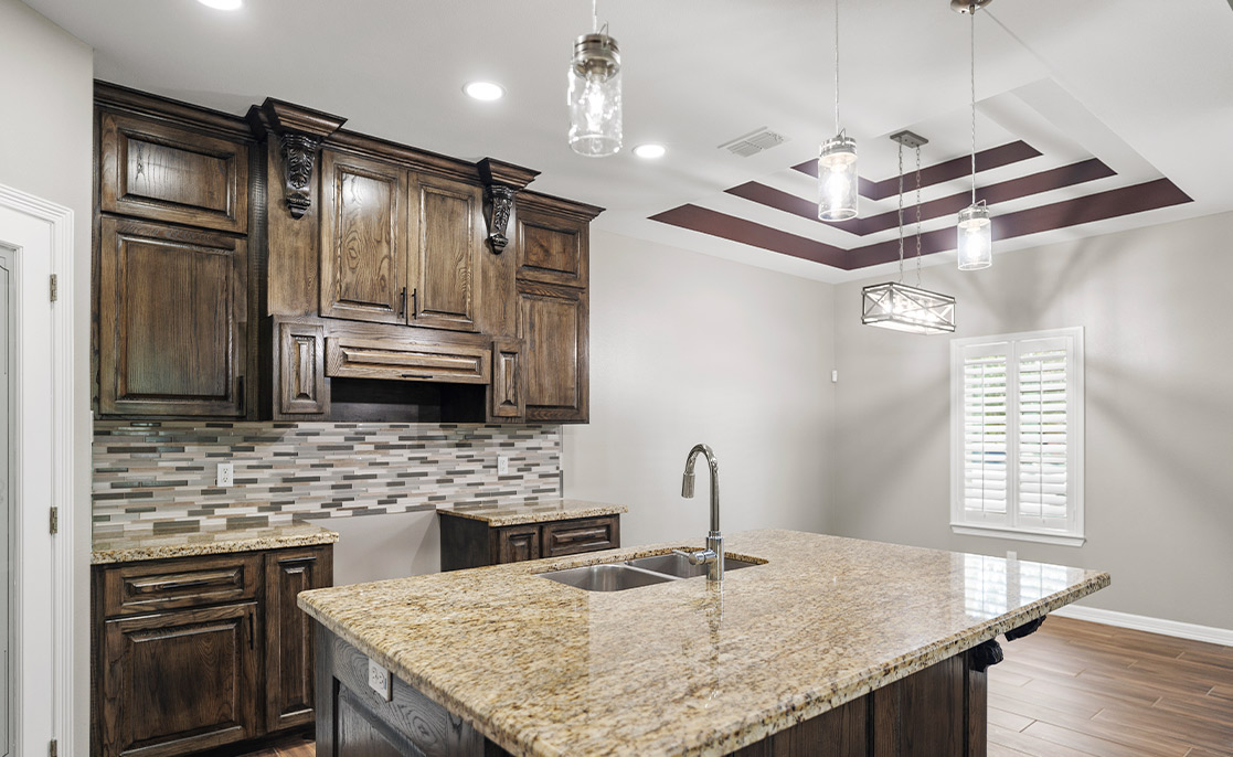 A well-designed kitchen with elegant granite countertops and rich wood cabinets, showcasing a blend of luxury and practicality.