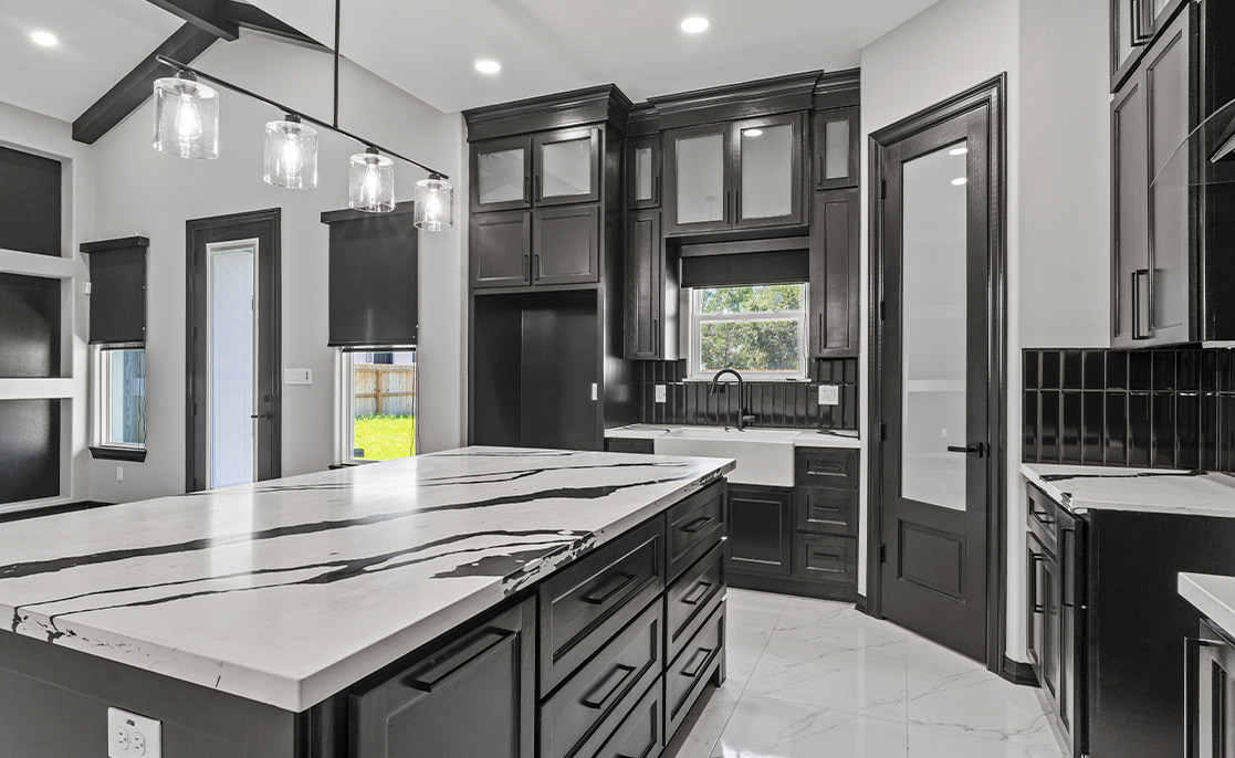 A contemporary kitchen with elegant black cabinetry and pristine white countertops, showcasing a potential home value increase.
