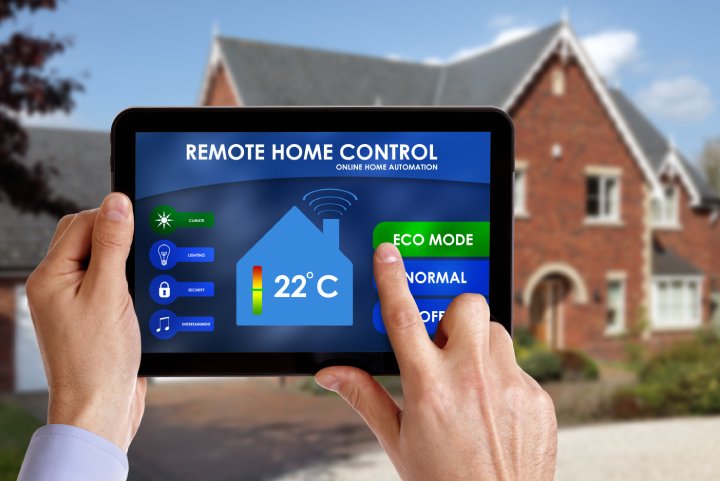 Holding a smart energy controller or remote home control online home automation system on a digital tablet. All screen graphics made up.