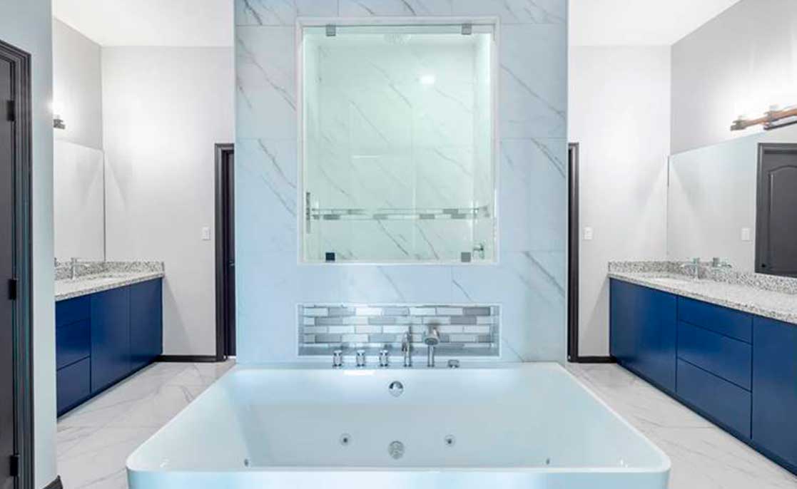 A spa-inspired bathroom featuring a large tub and elegant blue cabinets, creating a serene and relaxing atmosphere.