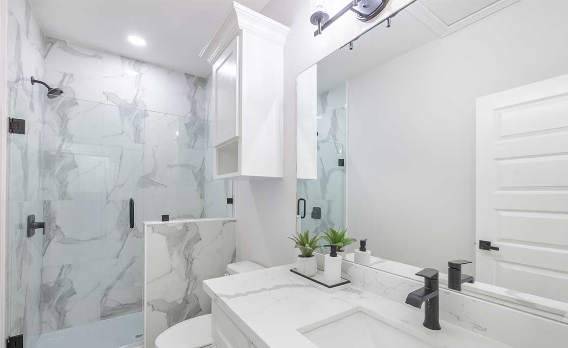 A modern bathroom featuring white marble walls and a sleek shower, designed in a functionalist style by Villanueva.