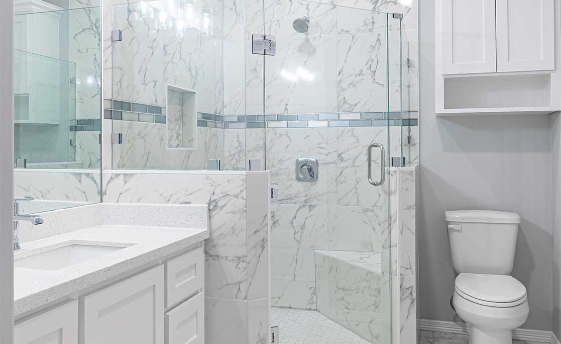 A bathroom showcasing a glass shower door and a toilet, reflecting Villanueva's functionalist design style.