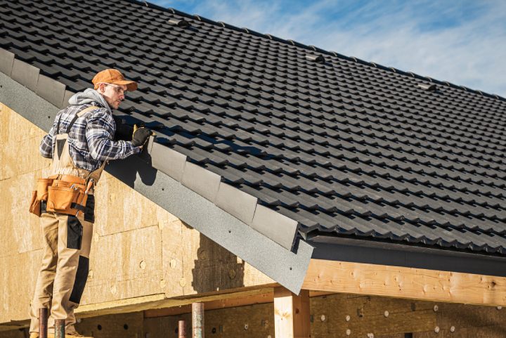 Black Ceramic House Tiles Roof Construction Theme. Contractor Roofer Checking on Finished Building Roof.