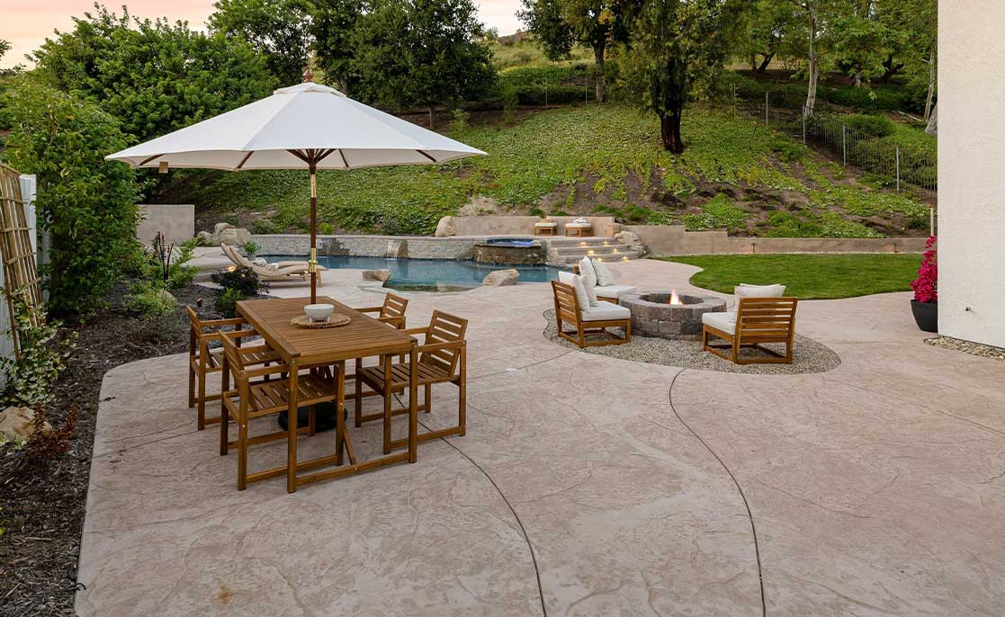 A cozy patio featuring a table, chairs, and a large umbrella, perfect for outdoor dining and relaxation in Texas.