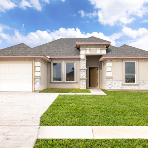 Modern home exterior with driveway, lawn, and cloudy sky backdrop.